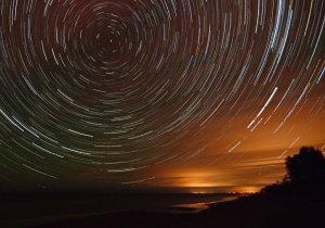 The stars make arcs in the sky in long exposures. This image was composed from about 120 individual wide angle photos taken with a Nikon D7000 on a tripod.