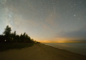 Lurgan Beach at night, with an unexplained visitor. A 77 second exposure taken om 19 August 2012 at 10:29 PM EST. The red glow along the horizon is light pollution from Michigan, 80 km away. The glow above the trees to the left is a combination of the Milky Way and the Point Clark Lighthouse. Off in the distance, a reddish object moved along. I contacted the Royal Astronomical Society of Canada to get help with ID. Might be a satellite or an aircraft, but they couldn't pin it down either. 