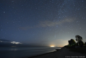 A short exposure of Lake Huron, looking north from Lurgan Beach, Ontario. On the horizon are a thunderstorm and the lights of a nuclear power plant and the town of Kincardine. Photographed 18 August 2012.